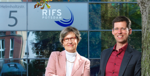 Doris Fuchs und Mark Lawrence stehen vor der verspiegelten Fassade des RIFS
